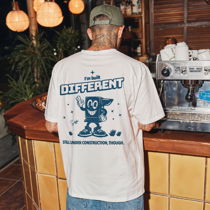 Person wearing a t-shirt with a graphic design in a coffee shop setting