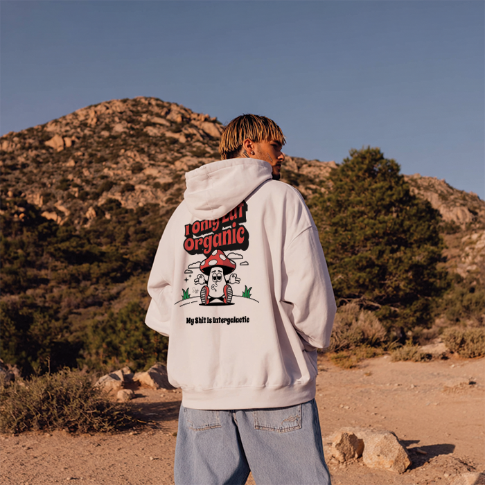 Person wearing a hoodie with a graphic design in a desert landscape