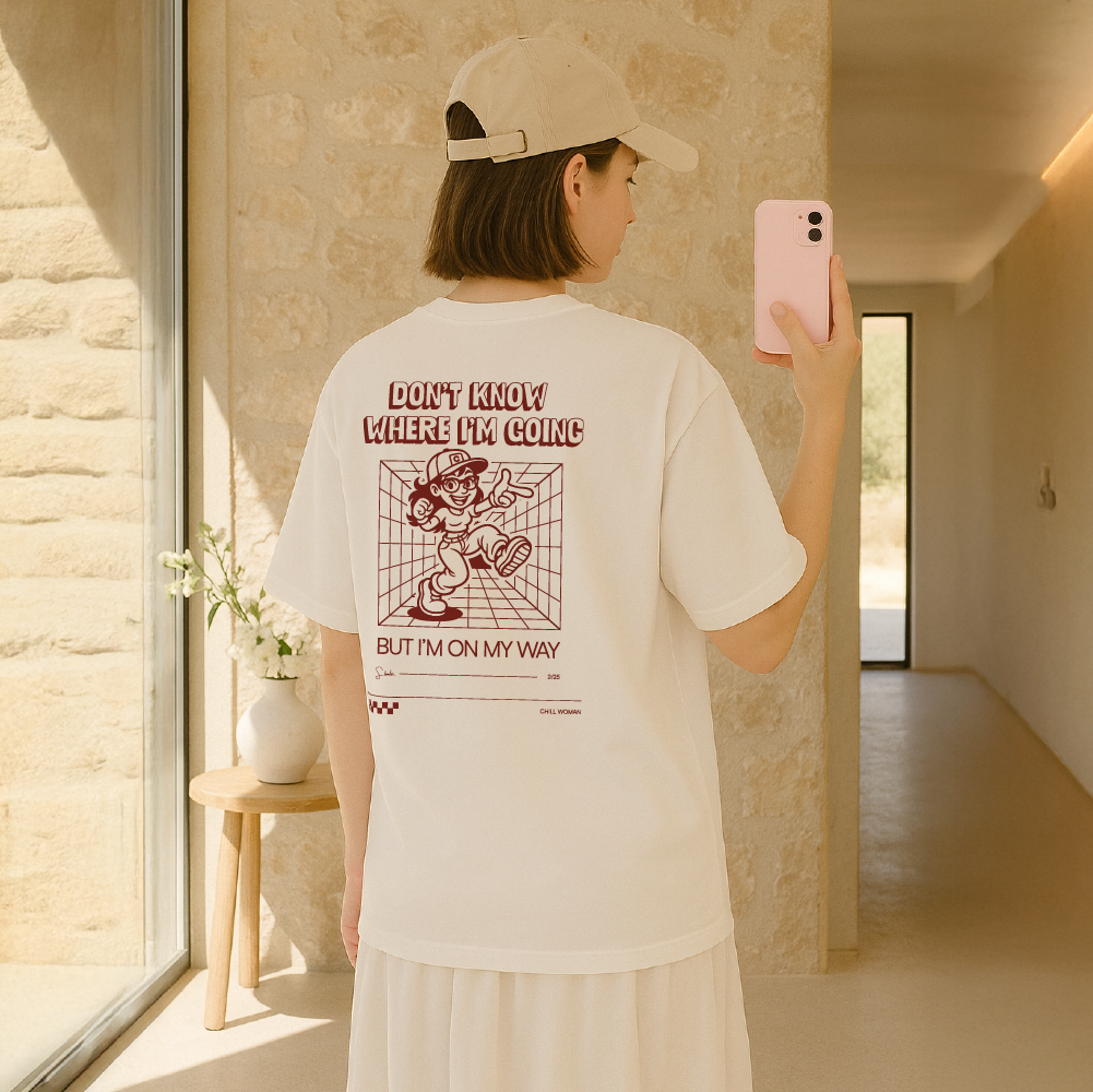 Person wearing a white t-shirt with text and graphics, standing in a modern indoor setting.