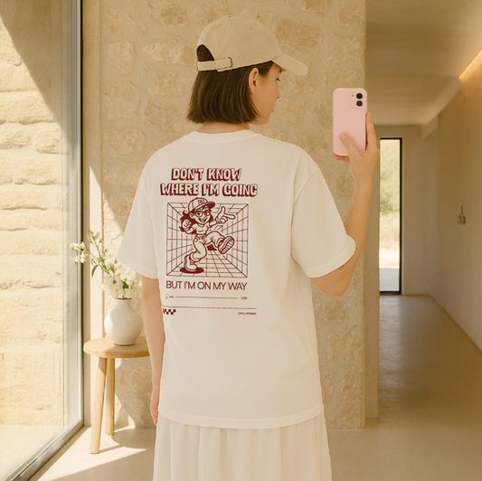 Person wearing a white t-shirt with text and graphics, standing in a modern indoor setting.