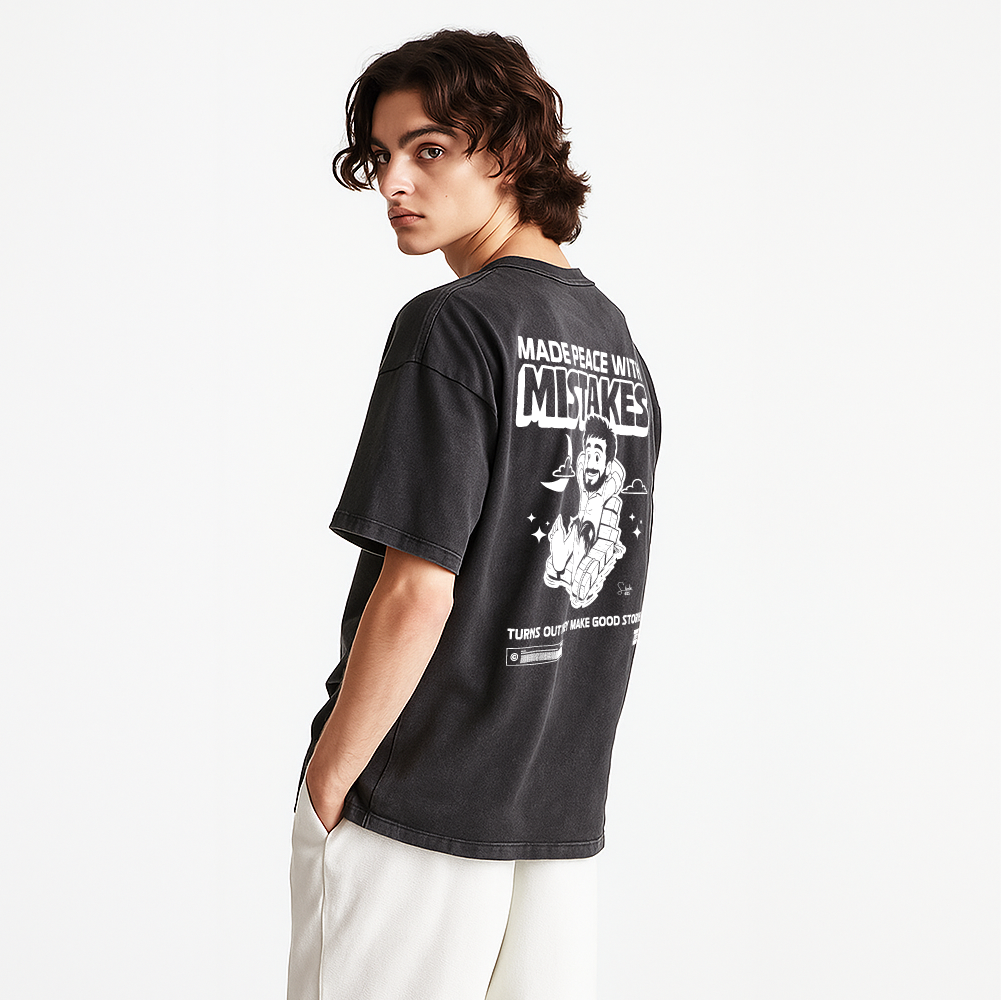 Person wearing a black t-shirt with graphic design and text on the back, standing against a white background