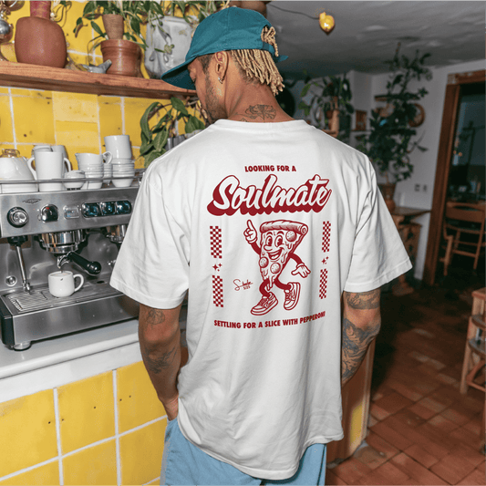 Person wearing a white t-shirt with a graphic design in a cafe setting