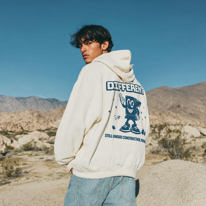 Person wearing a hoodie with a graphic design in a desert setting