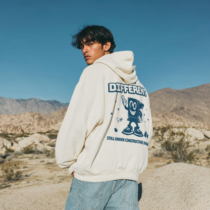 Person wearing a hoodie with a graphic design in a desert setting