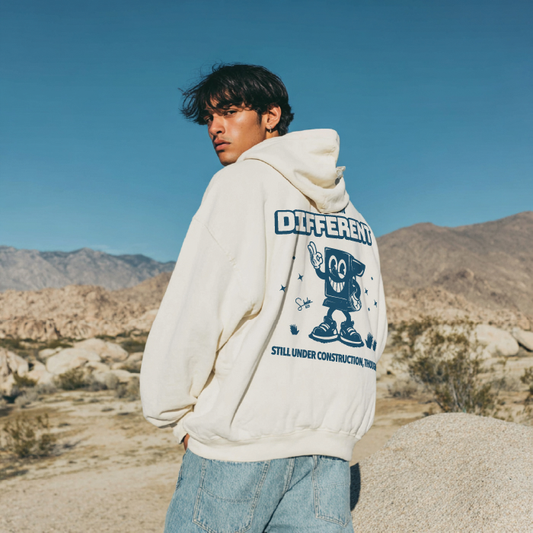 Person wearing a hoodie with a graphic design in a desert setting