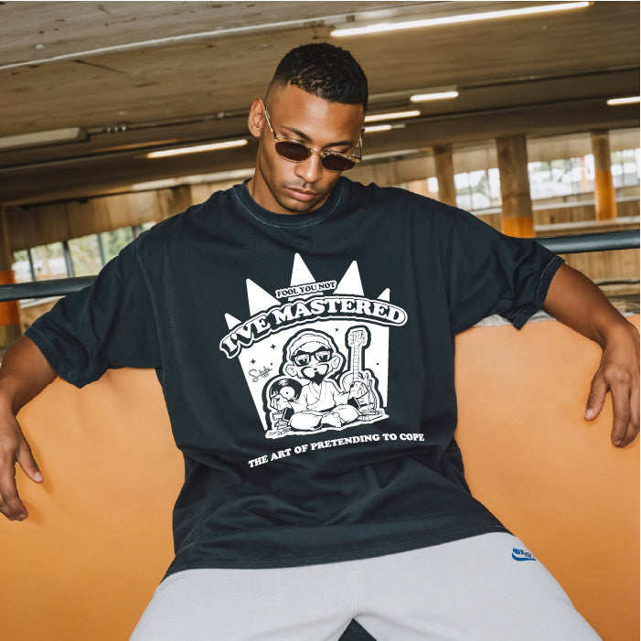 Man wearing a black t-shirt with a graphic design sitting on an orange bench.