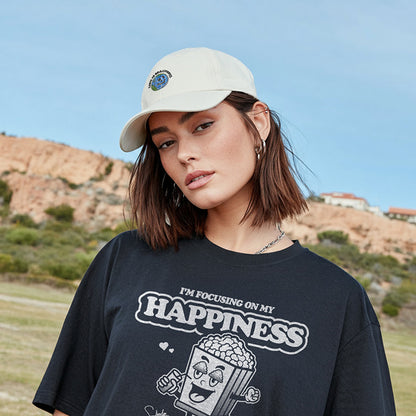 Person wearing a black t-shirt with 'I'm Focusing on My Happiness' text and graphic, standing outdoors.