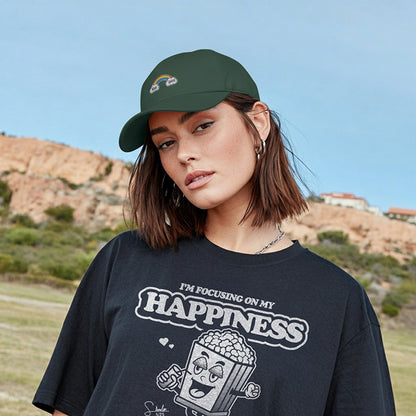 Person wearing a black t-shirt with 'I'm focusing on my happiness' text and graphic, standing outdoors.