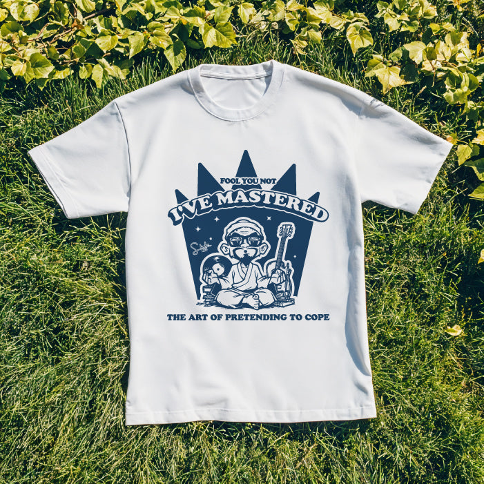 White t-shirt with blue graphic design on grass