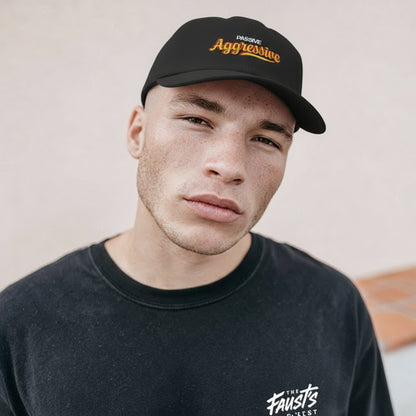 Man wearing a black cap with 'Passive Aggressive' text and a black shirt with 'The Fausts' text.