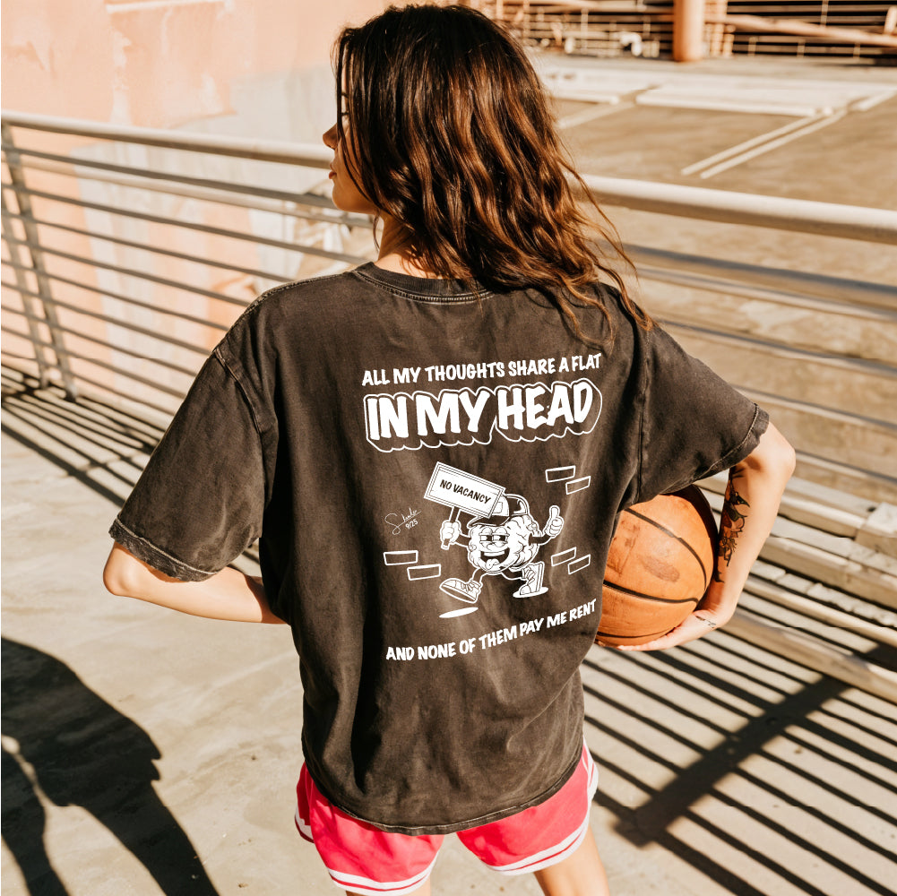 Person holding a basketball wearing a black t-shirt with a humorous graphic and text.
