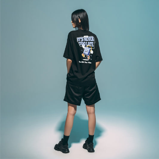 Person wearing a black t-shirt with a graphic design on the back against a plain background