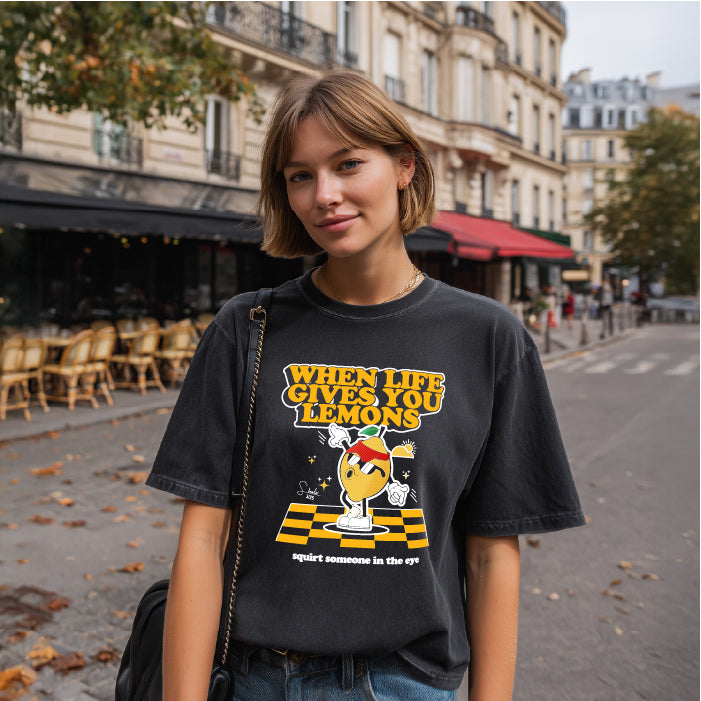 Person wearing a black t-shirt with a graphic design in an urban setting